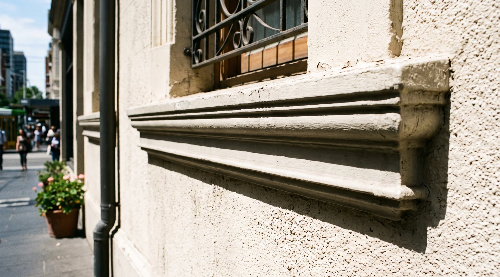Horizontal wall moulding banding detail on a rendered Melbourne facade casting a shadow line