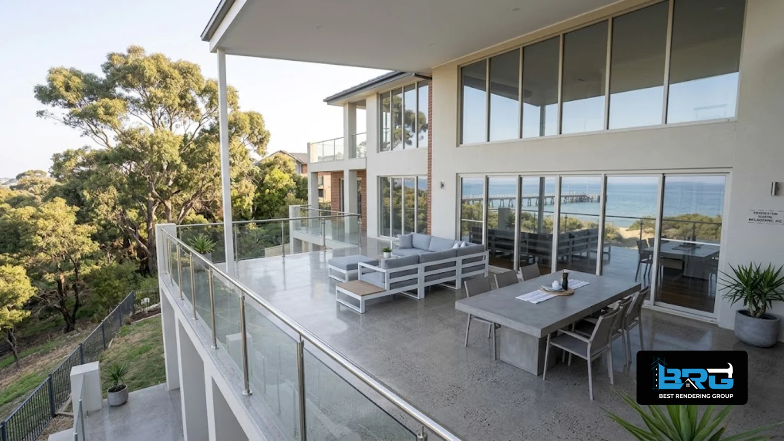 A newly completed polished concrete outdoor entertaining area beside a large elevated home in Frankston South, Melbourne, with a glimpse of the bay in the distance.