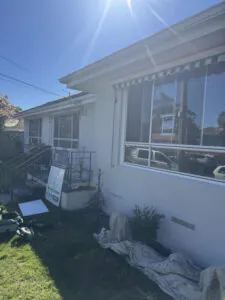Completed light grey exterior render on the front of a Keysborough home with striped awnings.