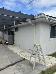 Completed rear exterior render featuring a heat pump unit, pergola, and clean roofline edge.